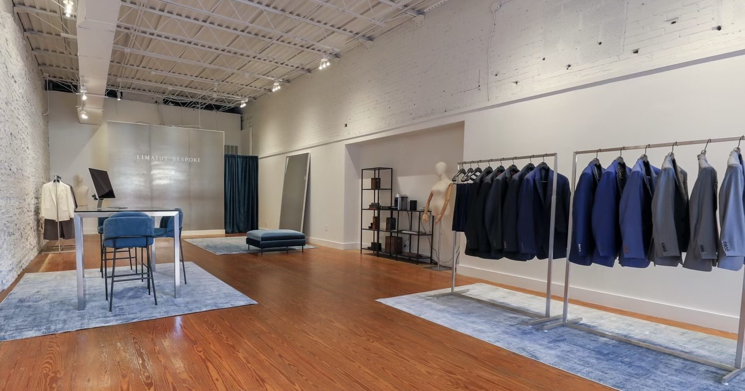 Limatus Bespoke private showroom in Raleigh, NC — racks of custom-tailored suits and bespoke fitting area